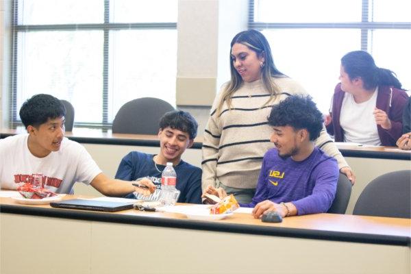 Yessenia Aguillon, TRIO Upward Bound program coordinator, stands behind students who are seated