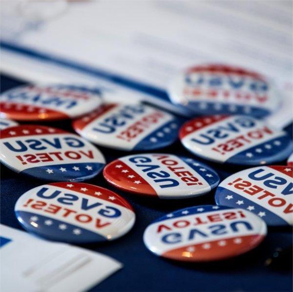 Several buttons that read 'GVSU Votes!' on a table.